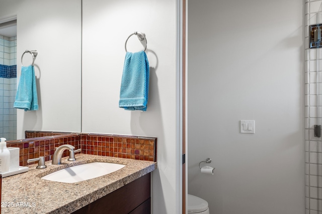 bathroom featuring tasteful backsplash, vanity, and toilet