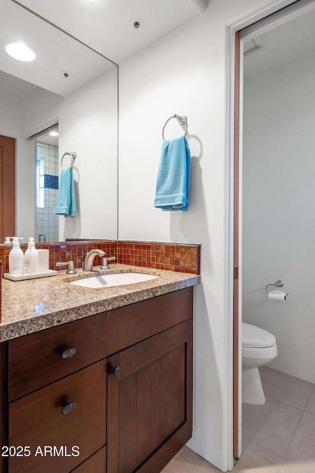 bathroom with tasteful backsplash, recessed lighting, toilet, vanity, and tile patterned flooring