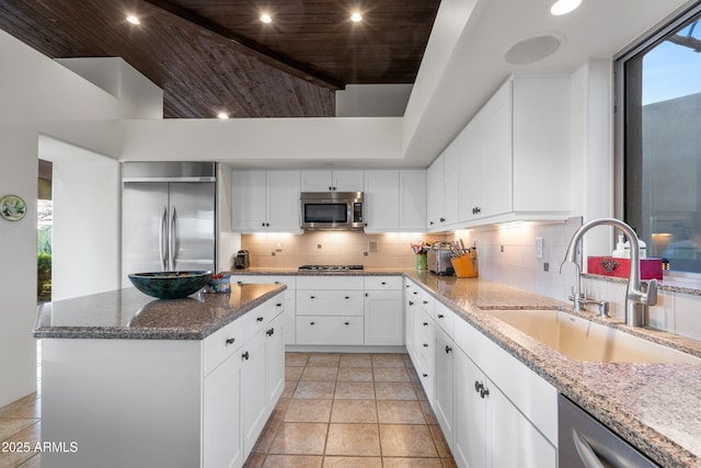 kitchen with recessed lighting, a sink, appliances with stainless steel finishes, dark stone counters, and tasteful backsplash