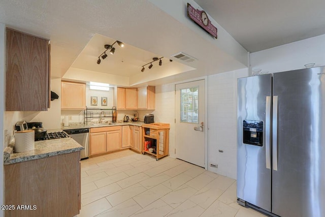 kitchen featuring light brown cabinets, a tray ceiling, a sink, stainless steel appliances, and marble finish floor