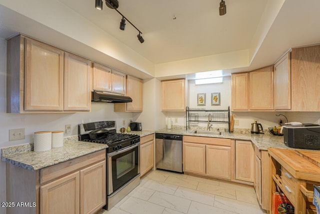 kitchen with under cabinet range hood, appliances with stainless steel finishes, light brown cabinets, and a sink