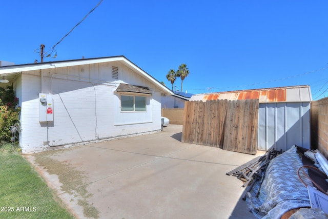 view of side of home featuring a patio area and fence