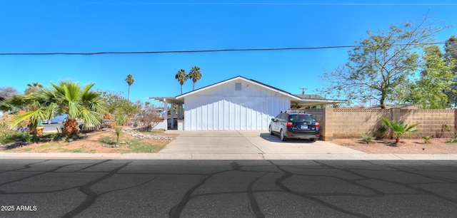 view of front of house featuring driveway and fence