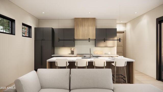 kitchen featuring pendant lighting, sink, a kitchen breakfast bar, and a kitchen island with sink