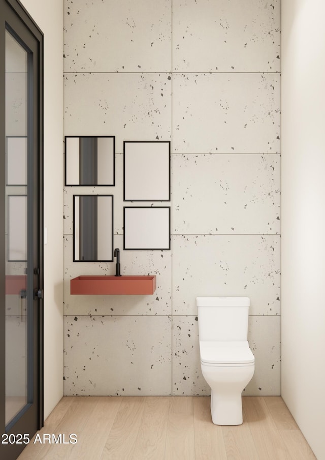 bathroom featuring wood-type flooring and toilet