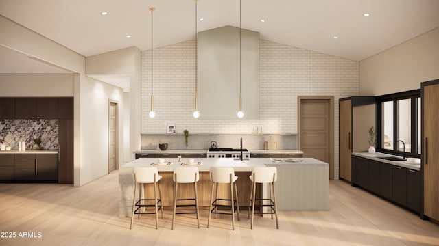 kitchen featuring a spacious island, a breakfast bar, high vaulted ceiling, and light wood-type flooring