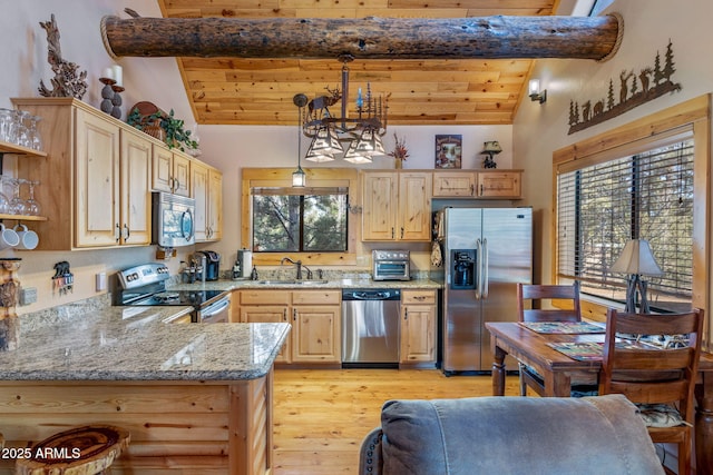 kitchen featuring sink, hanging light fixtures, kitchen peninsula, light brown cabinetry, and appliances with stainless steel finishes