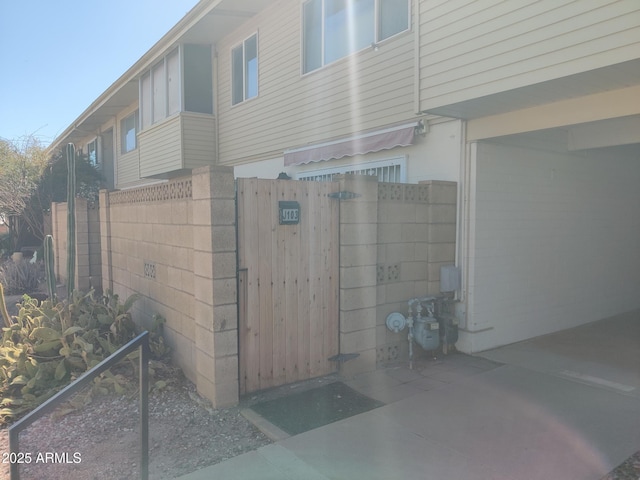 view of side of home with a gate and fence