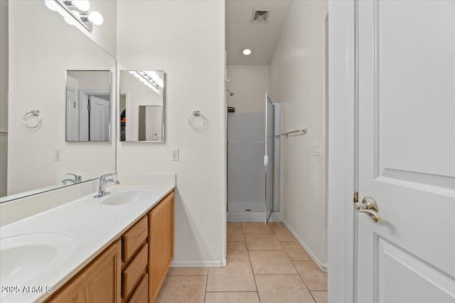 bathroom with visible vents, double vanity, a sink, tile patterned flooring, and a shower stall