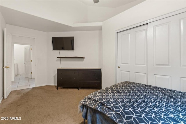 carpeted bedroom with a closet, baseboards, a ceiling fan, and vaulted ceiling