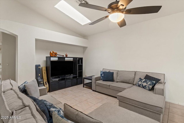 tiled living area featuring vaulted ceiling with skylight and ceiling fan