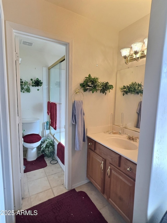 bathroom featuring visible vents, toilet, tile patterned floors, combined bath / shower with glass door, and vanity