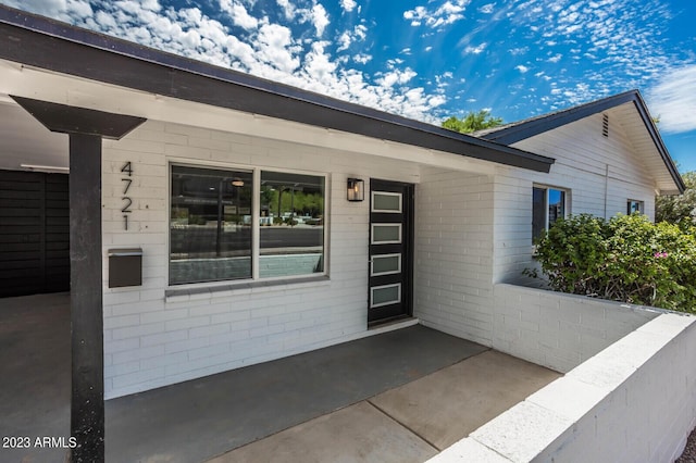 view of exterior entry featuring a patio area