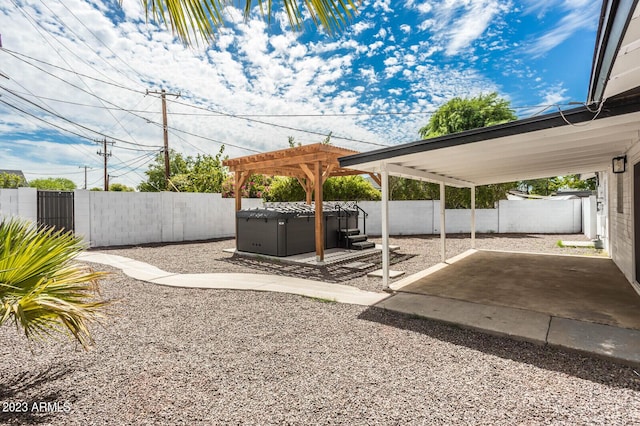 view of yard with a hot tub, a pergola, and a patio area