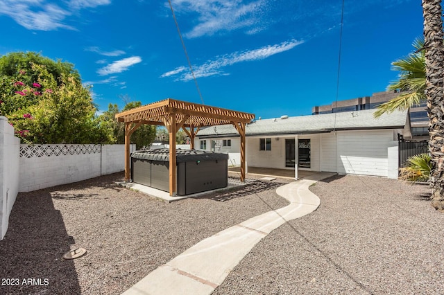 view of patio with a hot tub and a pergola