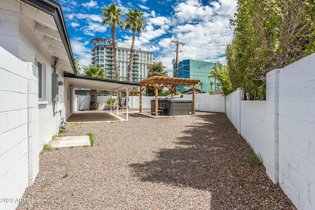 view of yard with a hot tub and a pergola