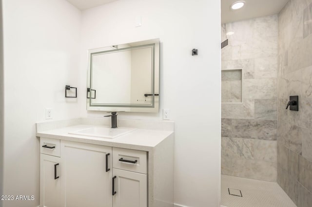 bathroom with vanity and tiled shower