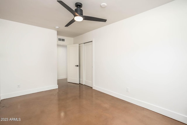 unfurnished bedroom with concrete flooring, a closet, and ceiling fan