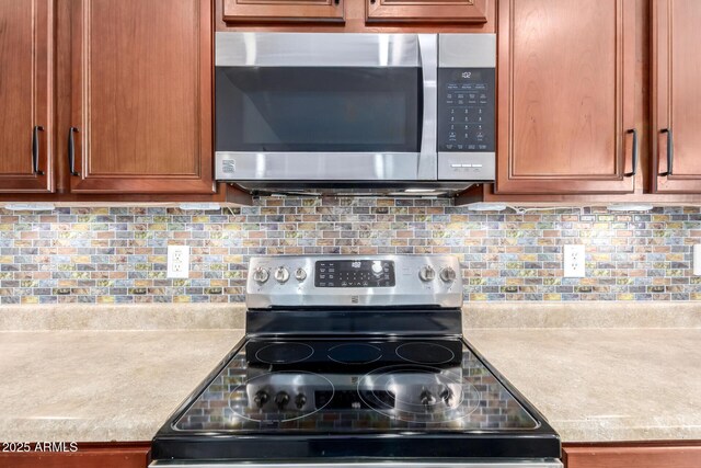18072 W Paradise Ln, Surprise, AZ 85388 - kitchen featuring light countertops, decorative backsplash, stainless steel appliances, and brown cabinets