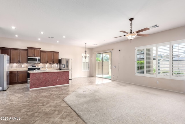 18072 W Paradise Ln, Surprise, AZ 85388 - kitchen with visible vents, appliances with stainless steel finishes, ceiling fan with notable chandelier, open floor plan, and an island with sink