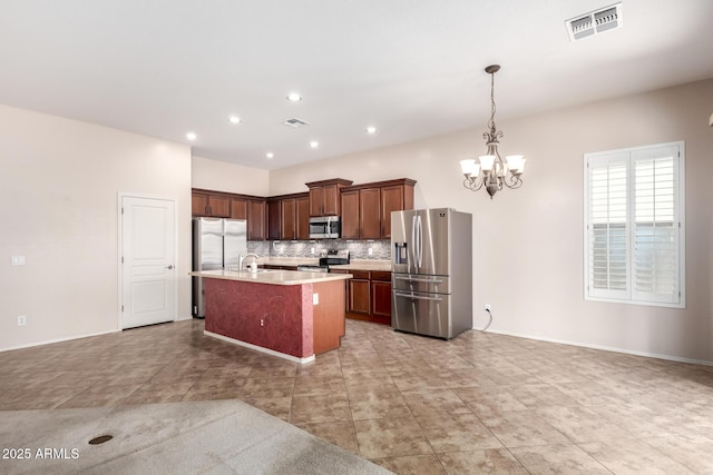 18072 W Paradise Ln, Surprise, AZ 85388 - kitchen with an inviting chandelier, light countertops, stainless steel appliances, decorative backsplash, and visible vents