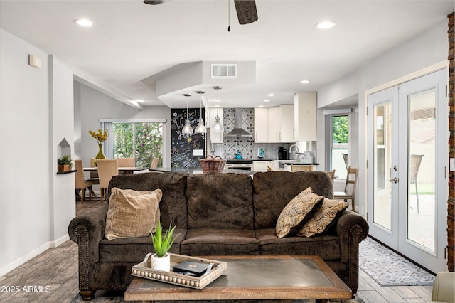 living room featuring french doors, ceiling fan, and sink