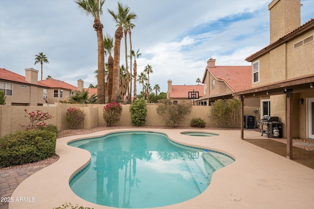 view of pool with area for grilling, a patio area, and an in ground hot tub