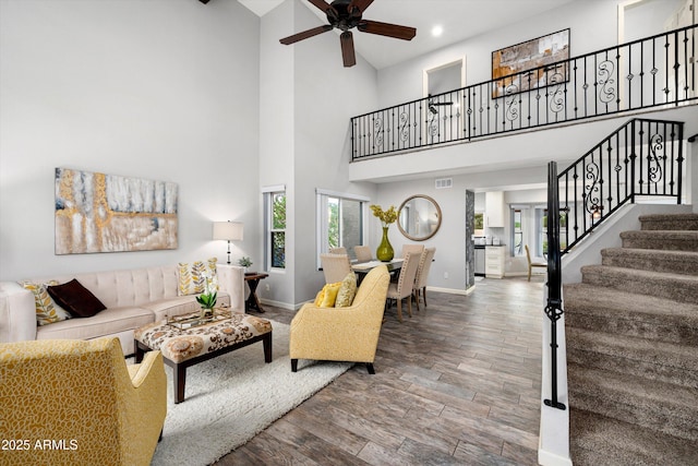 living room featuring ceiling fan and a high ceiling