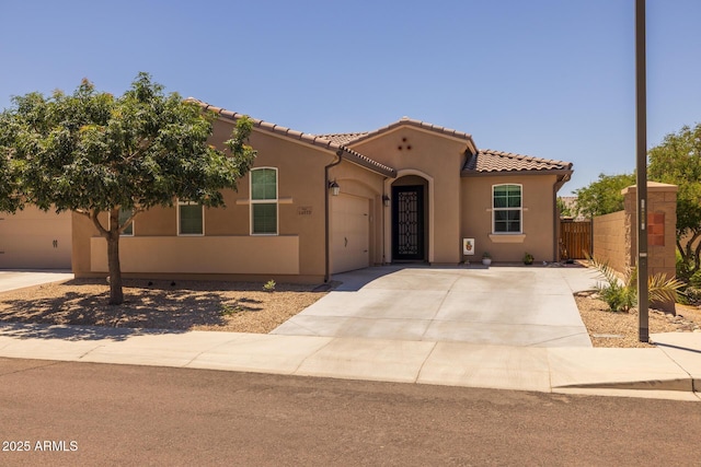 14573 W Reade Ave, Litchfield Park, AZ 85340 - mediterranean / spanish-style home with concrete driveway, stucco siding, an attached garage, and a tile roof