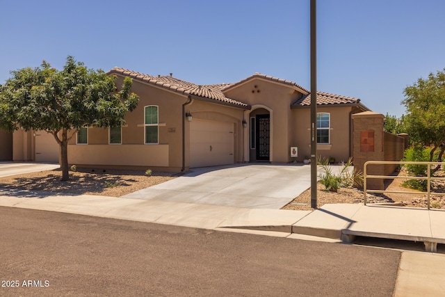 14573 W Reade Ave, Litchfield Park, AZ 85340 - mediterranean / spanish-style house with an attached garage, stucco siding, driveway, and a tile roof