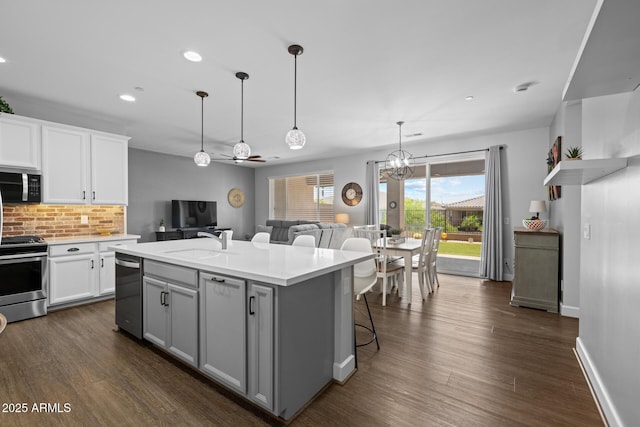 14573 W Reade Ave, Litchfield Park, AZ 85340 - kitchen with appliances with stainless steel finishes, backsplash, light countertops, white cabinets, and dark wood-type flooring