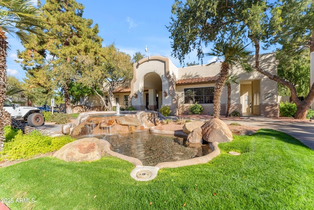 mediterranean / spanish house featuring a front yard