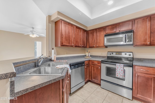 kitchen featuring appliances with stainless steel finishes, a raised ceiling, ceiling fan, sink, and light tile patterned floors