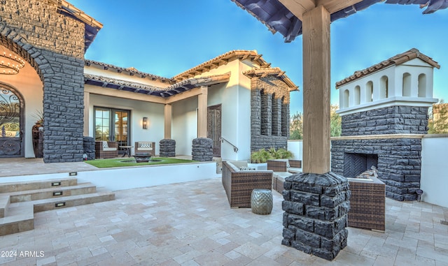 view of patio with an outdoor living space with a fireplace