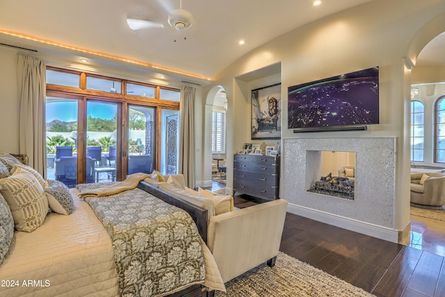 bedroom with ceiling fan, multiple windows, hardwood / wood-style flooring, and a multi sided fireplace