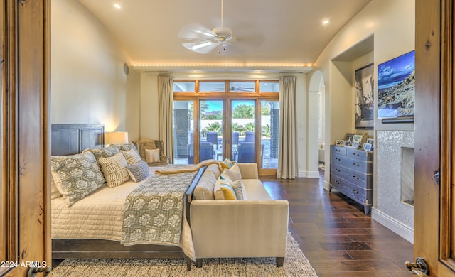 bedroom featuring dark wood-type flooring, vaulted ceiling, access to exterior, and ceiling fan