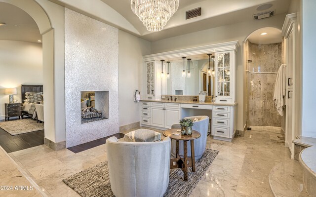 bathroom featuring tiled shower, vanity, and wood-type flooring