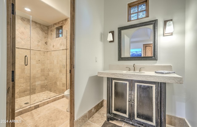 bathroom featuring toilet, vanity, and a shower with door