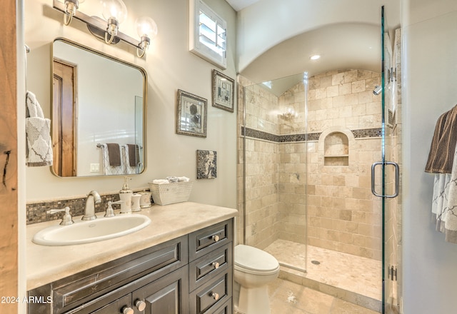 bathroom with a shower with shower door, vanity, and toilet