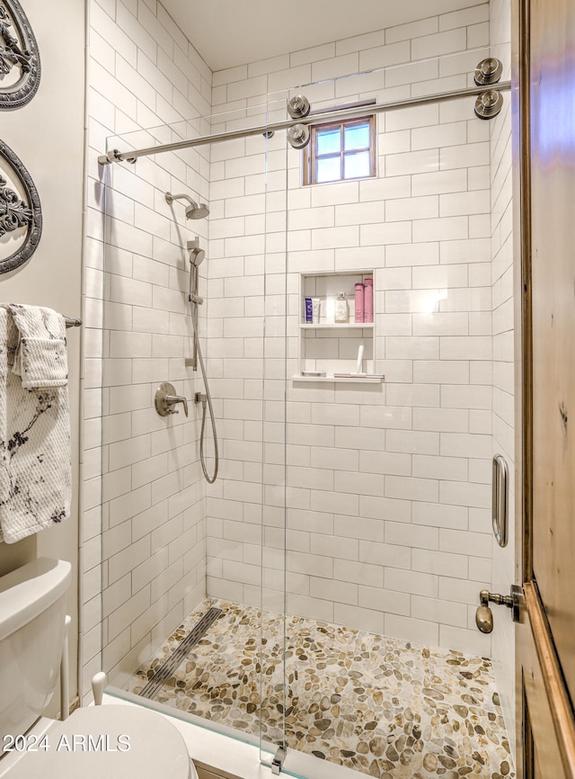 bathroom featuring walk in shower and toilet