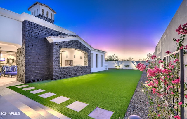 yard at dusk with a patio area