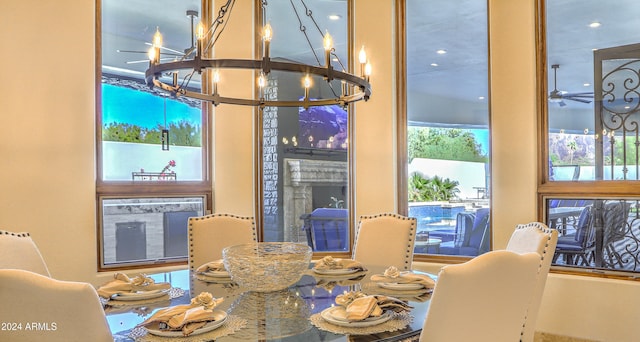 dining area with ceiling fan with notable chandelier