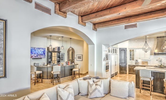 living room featuring bar, beam ceiling, and wood ceiling