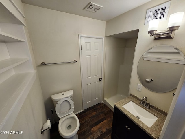 bathroom featuring a shower, toilet, vanity, and hardwood / wood-style flooring