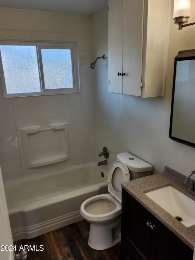 full bathroom featuring washtub / shower combination, hardwood / wood-style floors, vanity, and toilet