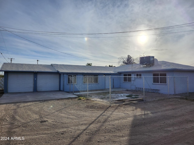 view of front of property featuring a garage and central AC unit