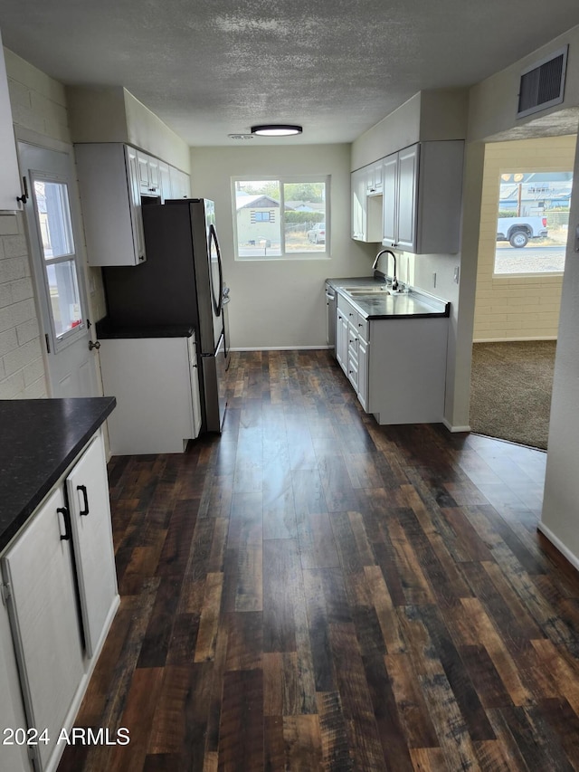 kitchen with stainless steel fridge, dark hardwood / wood-style flooring, white cabinetry, and sink