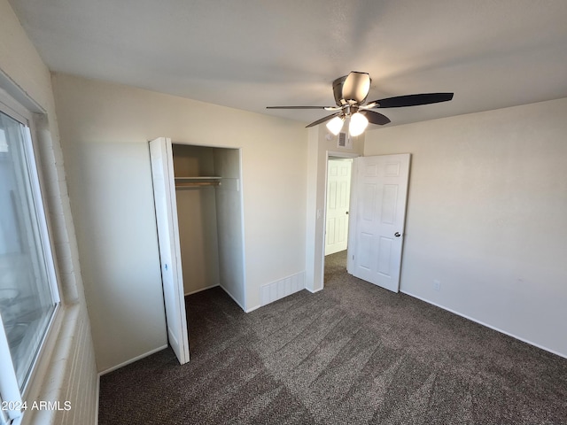 unfurnished bedroom with ceiling fan, a closet, and dark carpet