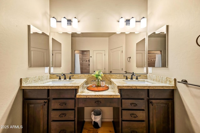 full bath with double vanity, a shower, and a sink