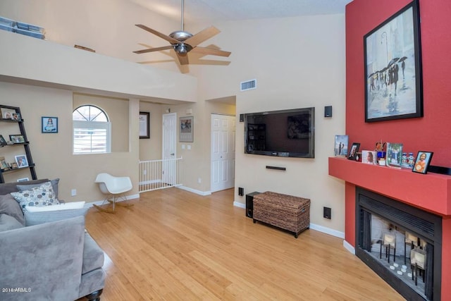 5640 E Bell Rd Unit 1099, Scottsdale, AZ 85254 - living room with a fireplace, wood finished floors, a ceiling fan, and vaulted ceiling